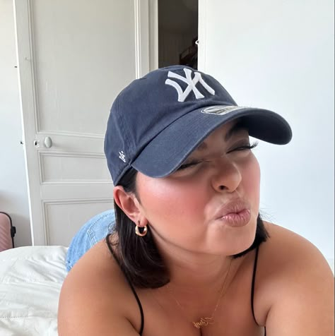 yankees baseball cap, cute short hair, bob hair cut inspo, mini gold hoops, bodysuit, jeans, cute room Nyc Baseball Cap Outfit, Shirt Hair Hat, Ball Cap With Bangs, Short Hair With Cap Hats Baseball, Hat With Bob Haircut, Short Bob With Baseball Cap, Short Hair In Hats Baseball, Short Hair Cap Outfit, Short Hair And Beanie