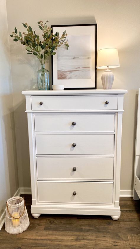 #talldresserdecor #bohocoastal #bedroomdecor #bedroomideas #moderncoastaldecor #coastalbedroom #decor #interiordecorating Chest Of Drawers Top Decor, Style Tall Dresser Top, Vertical Dresser Decor, White Dresser In Living Room, Y’all Dresser Decor, Tall Dresser Ideas Bedroom, Tall Dresser Next To Bed Ideas, Above Tall Dresser Decor, Styling A Tall Dresser Top