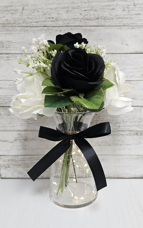 These beautiful centerpieces are perfect for your next event and include a glass vase with a set of warm white LED fairy lights, one black and white silk rose arrangement, and a black ribbon bow.  They are very popular for weddings, baby showers, parties, corporate events, holiday events, and any other event that requires table centerpieces. They also look great in any room of your house or office. To see other lighted jar options and all of my other listings, please view my shop: https://www.et Prom Tables Decorations, Elegant Black Table Setting, Red And Black Roses Centerpieces, Black White And Red Centerpieces, Centerpieces With Cylinder Vases, Men’s Birthday Table Decor, Black And White Bridal Shower Centerpieces, Black White Burgundy Wedding Decor, Black And White Affair Party Decor