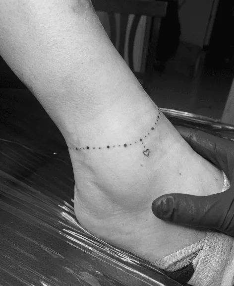 55 Anklet Tattoo Designs To Make Your Ankles Shine! Lil Tatoos, Chilli Tattoo, Ankle Bracelets Tattoos For Women, Charm Anklet Tattoo, Normal Tattoo, Wrap Around Ankle Tattoos, Small Infinity Tattoos, Anklet Tattoos For Women, Anklet Tattoo