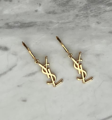 ✨ Beautiful reworked YSL Earrings & Necklaces are now back in stock! ✨ Get yours now before they’re gone again! ✨ Repurposed from authentic pre-loved YSL necklace charms and handcrafted in Melbourne with love 🫶🏼 ✨ Free shipping Australia wide. #yvessaintlaurent #yvessaintlaurentjewellery #repurposedjewelry #vintagejewels #vintageaesthetic #goldjewellery #sustainablejewelry #saintlaurent #prelovedysl #aestheticphotography #vintageysl #reworkedvintage #designerjewelry #ysl #upcycledjewelry #v... Ysl Accessories Jewelry, Branded Earrings, Gold Earring Aesthetic, Luxury Must Haves, Ysl Accessories, Ysl Bracelet, Ysl Earrings, Saint Laurent Earrings, Ysl Necklace