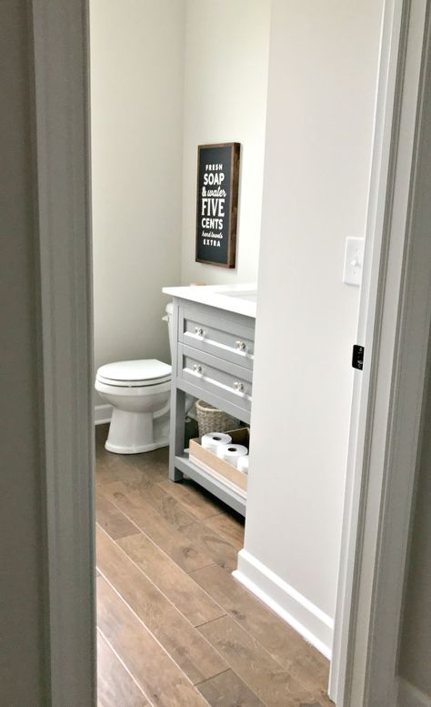 The first full room makeover in the new house! from Thrifty Decor Chick Wood Floor Powder Room, Shiplap Powder Room, Before And After Home, Wood Floor Bathroom, Room Maker, Built In Electric Fireplace, Powder Room Makeover, Thrifty Decor Chick, Gray Vanity