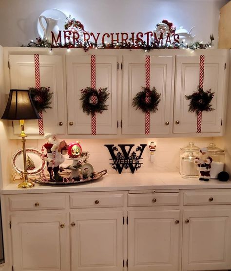 Top Of Cabinet Decorating Christmas, Christmas Decoration For Kitchen Cabinet, White Kitchen Cabinets Christmas Decor, Christmas Decor For Cabinet Tops, Christmas Present Kitchen Cabinets, Christmas Decorated Kitchen Cabinets, Christmas Cabnit Decor, Decorating Entertainment Center For Christmas, Kitchen Decorating Ideas Christmas