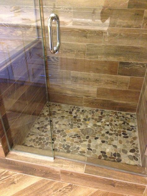 Showers With River Rock Floors, Shower Tile Ideas Wood Look, Cream Color Shower Tile, Pebble Shower Floor River Rocks, River Rock Shower Ideas, Pebble Floor Shower Ideas, Pebbles Bathroom, River Rock Shower Floor, Wood Tile Shower