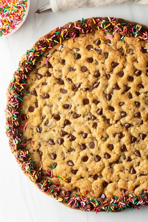 Get ready to indulge in every bit of this Chocolate Chip Cookie Cake Recipe! 🍪🎂 This dessert will take your taste buds on a journey to delight, with its moist, gooey center and crunchy outer layers. Follow the step-by-step instructions and impress your loved ones with this scrumptious homemade treat. 12 Inch Cookie Cake Recipe, Chocolate Cookie Cake, Easy Cookie Cake Recipe, Cookie Cake Recipes, Great American Cookie Cake Recipe, Big Cookie Cake, Homemade Cookie Cakes, Chocolate Chip Cookie Pizza, Chocolate Chip Cookie Cake Recipe