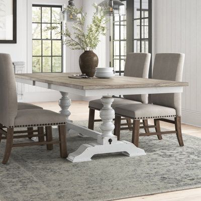 This modern farmhouse dining table brings rustic charm to your dining room. Its trestle base and weathered gray finish contrast beautifully with the light brown top, creating an inviting atmosphere for family meals and gatherings. Made from a combination of solid wood and oak veneers, this table showcases natural wood grain variations for a unique, authentic look. The table features a removable leaf, allowing you to extend the seating capacity to six when needed. Enjoy memorable meals and conver Farmhouse Dining Table Sets, 72 Inch Dining Table Rectangle, Light Colored Dining Table, Painted Farmhouse Table And Chairs, Light Brown Farmhouse Table, Light Wood Dining Room Table, Dining Table Upholstered Chairs, Kitchen Tables Farmhouse, Dining Table Seats 10