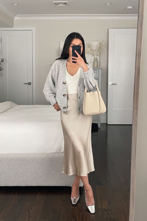 Quince slip skirt, quince cardigan, songmont bag, J Crew heels Silk Dress And Cardigan Outfit, Silk Slip Dress With Cardigan, White Cardigan With Skirt, Satin Skirt And Cardigan Outfit, Cardigan And Satin Skirt, Songmont Bag, Quince Cardigan, Knitted Skirt Outfit, Slip Skirt Outfits