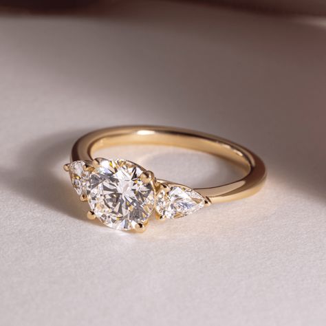 Exceptional lab-grown diamond ring showcasing a trilogy of sparkling round brilliants, totaling 1.25 carats, set in lustrous 14K/18K yellow/white/rose gold. This exquisite three-stone ring symbolizes the past, present, and future of your love, making it a perfect engagement or anniversary gift. 𝐅𝐞𝐚𝐭𝐮𝐫𝐞𝐬:• 𝐌𝐚𝐝𝐞 𝐭𝐨 𝐎𝐫𝐝𝐞𝐫• 𝐌𝐞𝐭𝐚𝐥: 𝟏𝟒𝐊 𝐆𝐨𝐥𝐝 | 𝟏𝟖𝐊 𝐆𝐨𝐥𝐝 | 𝟗𝟓𝟎 𝐏𝐥𝐚𝐭𝐢𝐧𝐮𝐦• 𝐁𝐚𝐧𝐝 𝐂𝐨𝐥𝐨𝐫𝐬: Rose Gold, Yellow Gold & White Gold• 𝐁𝐚𝐧𝐝 𝐖𝐢𝐝𝐭𝐡: 1.80 MM• 𝐁𝐚𝐧𝐝 𝐓𝐡𝐢𝐜𝐤𝐧𝐞𝐬𝐬: 1.60 MM 𝐂𝐞𝐧𝐭𝐞𝐫 𝐬𝐭𝐨𝐧𝐞:• 𝐒𝐭𝐨𝐧𝐞 - Lab Grown Diamond• 𝐒𝐡𝐚𝐩𝐞 - Brilliant Cut Round• 𝐂𝐚𝐫𝐚𝐭 𝐖𝐞𝐢𝐠𝐡𝐭 - 1.25 Carats• 𝐏𝐢𝐞𝐜𝐞𝐬 - 1 Piece• 𝐂𝐨𝐥𝐨𝐫 - F+• 𝐂𝐥𝐚𝐫𝐢𝐭𝐲 - VS1+• 𝐂𝐞𝐫𝐭𝐢𝐟𝐢𝐜𝐚𝐭𝐞 - 𝐈𝐆𝐈 | 𝐆𝐈𝐀 𝐒𝐢𝐝𝐞 𝐬𝐭𝐨𝐧𝐞𝐬:• Three Stone Engagement Rings Gold, Circle Engagement Rings, Three Diamond Engagement Ring, Past Present Future Ring, Engagement Rings Round Gold, Gold Band Engagement Rings, Trilogy Engagement Ring, Wedding Ring Styles, Wedding Rings Round