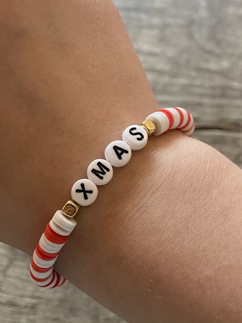 white, & red bracelet with xmas letters and a clip. Christmas Braclets Ideas Clay Beads, Xmas Bracelets Clay Beads, Cute Letter Bracelets, Bracelets For Christmas, Clay Bracelet Christmas, Christmas Diy Bracelet, Christmas Clay Bracelet Ideas, Xmas Bracelet Ideas, Clay Beads Bracelet Ideas Christmas