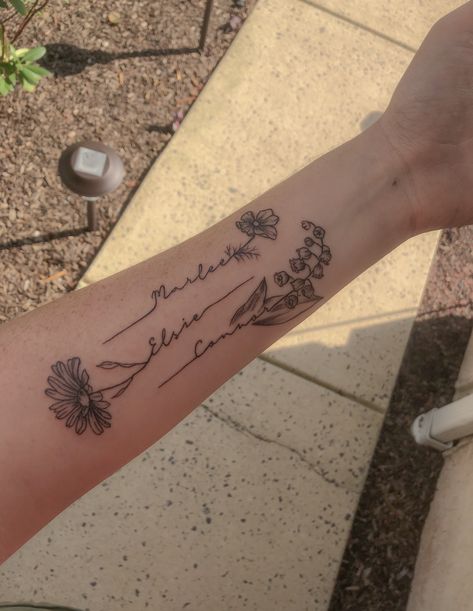 This tattoo was created for my 3 kiddos! Each child’s name goes with each of their birth month flowers. Cosmos for October, daisy for April, and lily of the valley for May. Tattoo Ideas With Names, Tato Nama, Name Flower Tattoo, Cosmos Tattoo, Daisy Tattoo Designs, Kid Name Tattoo, Flower Tattoo Ideas, Tattoos With Kids Names, Daisy Tattoo