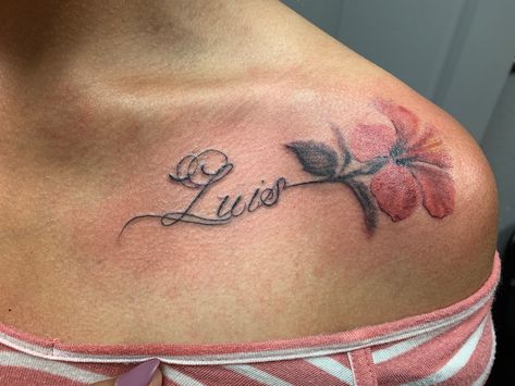 Elegant script tattoo with flower near collarbone with the name “Luis”. Name Collarbone Tattoo, Elegant Name Tattoos, Luis Name Tattoo, Lily Tattoo With Name, Collar Bone Tattoo Name, Collar Bone Name Tattoo, Collarbone Name Tattoo, Under Collar Bone Tattoos, Luis Tattoo