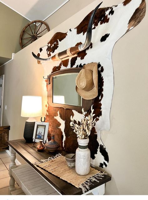 Cowhide Rug On Wall With Pictures, Boho Western Salon Decor, Bear Skin Rug On Wall, Apartment Decorating Country, Western Bar Cart Ideas, Cowhide Wall Decor Living Room, Light Western Aesthetic, How To Hang A Cowhide On The Wall, Cowhide Furniture Diy