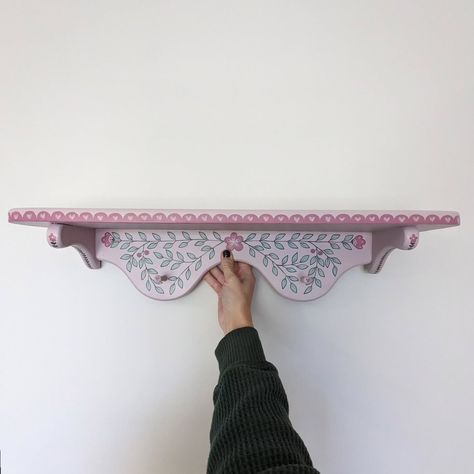 Little pink wooden shelf 🩷 #handpainted #handpaintedfurniture #handpaintedhomedecor #colorfulhome #colorfulinterior #interiordesign #folkart #boho #uniqueinteriors #fusionmineralpaint #smithfieldva #virginiaartist #upcyclefurniture #upcycle Folk Art On Furniture, Hand Painted Shelf, Shelf Painting Ideas, Lesbian Cottage, Painted Wall Shelf, Painted Things, Doodle Doodle, Folk Painting, Decoration House