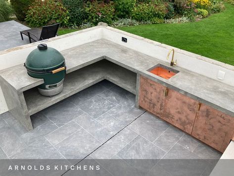 An XL Big Green Egg integrated into our cast-in-situ concrete kitchen with a solid copper sink and patinated copper hand-made doors. Concrete Kitchens, Big Green Egg Outdoor Kitchen, Outdoor Grill Island, Concrete Outdoor Kitchen, Stone Bbq, Christmas Patio Decorating Ideas, Outdoor Bbq Area, Barbecue Design, Christmas Patio