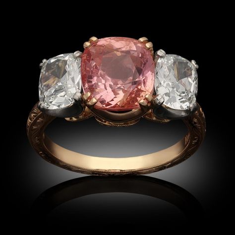 Hancocks 4.16ct Cushion Padparadscha Sapphire And Old Mine Cushion Diamond Three Stone Ring | BADA Padparadscha Sapphire Ring, Diamond Three Stone Ring, Blue Sapphire Diamond Ring, Cute Engagement Rings, Padparadscha Sapphire, Three Stone Ring, Blue Sapphire Diamond, Cushion Diamond, Cushion Cut Diamonds