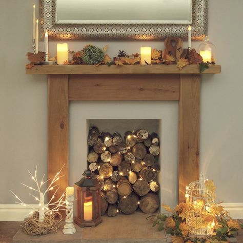 Wood Logs In Fireplace, Fireplace Filled With Logs, Decorative Logs In Fireplace, Fireplace With Logs Inside, Old Fireplace Decor Ideas, Covered Fireplace Ideas, Fireplace Logs With Lights, Fireplace With Candles Ideas, Logs In Fireplace Decorative