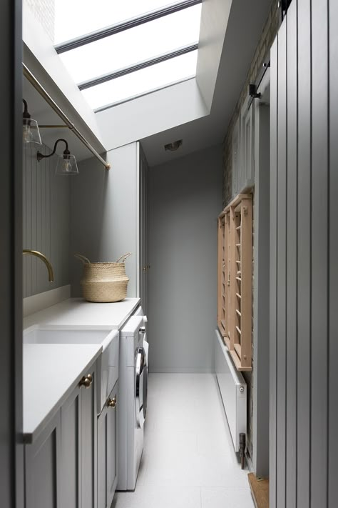 A functional use of a compact space in this utility room in a recently completed project in Dartmouth Park, North London. Ideal components of a utility are a rail for hanging, sink, drying rack, integrated laundry basket and a bench large enough to fold clothes. London Utility Room, Small Narrow Utility Room, Utility Room With Skylight, Conservatory Utility Room, Awkward Shape Utility Room, Utility Room In Kitchen, Ikea Metod Utility Room, Utility Room Hanging Rail, Skylight In Laundry Room