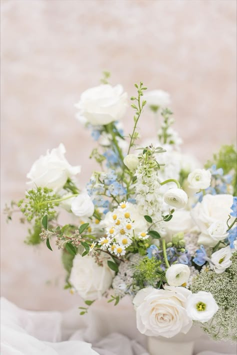 White wedding centerpiece with a hint of blue - adding a modern and romantic touch at any celabrtation #nofloralfoam #whitewedding #gardenstyle #microwedding White And Blue Flower Arrangements Simple Centerpieces, Blue White Yellow Flower Arrangements, Blue And White Baby Shower Flowers, Summer Garden Wedding Bouquet, Blue Wedding Flowers Table, Baby Blue Flower Arrangements, White Green Blue Yellow Wedding, Light Blue Floral Arrangements, Simple Blue Flower Centerpieces