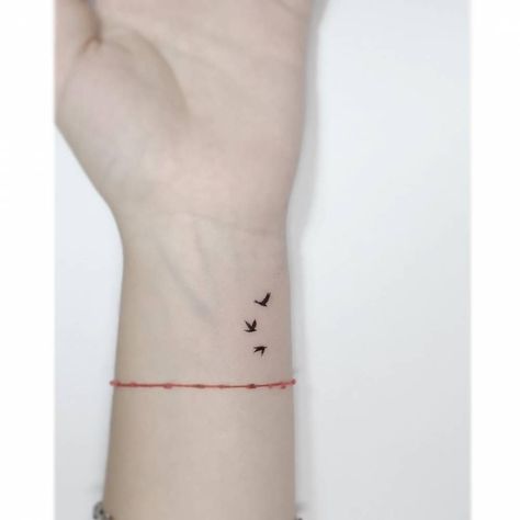 Minimalistic style flying birds tattooed on the wrist. Let It Be Tattoo With Birds, Three Small Birds Tattoo Simple, Tattoo Of Birds Flying, Small Bird Wrist Tattoos For Women, Birds Flying Tattoo Arm, Three Flying Birds Tattoo, Minimalist Tattoo Freedom, Birds On Wrist Tattoo, Tiny Sparrow Tattoos For Women