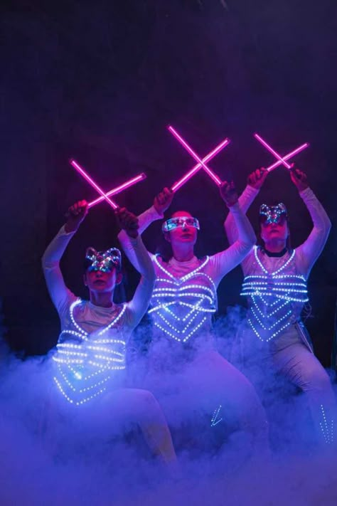 Dancers holding pink LED glowsticks to form an X shape while wearing LED corsets and surrounded by smoke Glow Costume, Sonic Room, Light Up Costumes, Led Costume, Christmas Aesthetics, Dance Props, Led Stick, Dance Crew, Led Dance