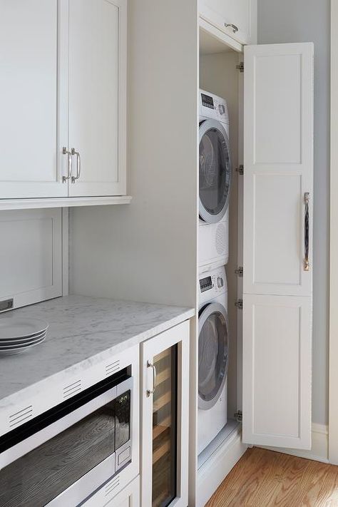 Galley style kitchen featuring hidden stacked washer and dryer in a white cabinet finished with a chrome pull. Hidden Laundry Rooms, Laundry In Kitchen, Grey Laundry Rooms, Stacked Laundry Room, Hallway Laundry, Hidden Laundry, Galley Style Kitchen, Stackable Washer And Dryer, Chicago Vintage