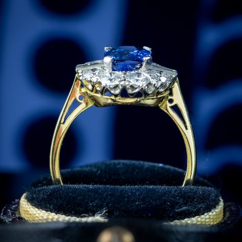 A stunning Art Deco-inspired sapphire diamond cluster ring adorned with a deep-blue cushion cut sapphire in the centre, framed by eight round transitional cut diamonds and two baguette cuts. The sapphire weighs approx. 2ct and is complemented beautifully by the bright, sparkling diamonds that have SI1 clarity – H colour, approx. 1ct total. The sapphire is claw set in a four-prong mount atop a platinum face with an 18ct yellow gold back and band. It’s a magnificent Art Deco-style statement pi... Edwardian Engagement Ring, Blue Cushions, Sapphire Diamond Ring, Diamond Cluster Ring, Art Deco Inspired, The Heavens, Memento Mori, Diamond Cluster, Antique Jewellery