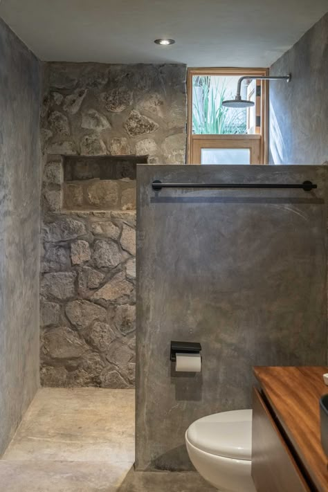 This Modern House Was Made From Locally Sourced Stone Rustic Stone Bathroom, Outside Bathroom Ideas Backyards, Stone Toilet Design, Bathroom Remodel Natural Stone, Outside Bathroom Ideas, Wood And Concrete Interior, Rustic Bathroom With Stone Walls, Out Door Stone Bath, Concrete Bathroom Design