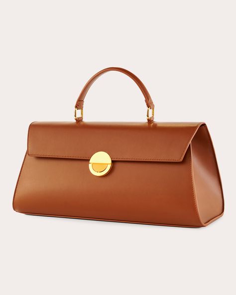 Inspired by activist and artist Josephine Baker, this top-handle bag exudes minimalist elegance with its horizontal orientation, polished goldtone hardware and calfskin leather construction. The flap opening is fastened with Objets Daso's signature push-lock closure to keep items stored safely in the pocketed interior. Includes removable shoulder strap Signature push-lock closure Top handle Goldtone hardware Interior pocket Outer: 100% calfskin leather Lining: 100% lambskin leather Store in dust bag Made in Italy Measurements Width: 14.56in Height: 6.29in Depth: 5.11in | Objets Daso Women's Josephine Handbag in Tan | Leather Josephine Baker, Leather Store, Tan Handbags, Stylish Purse, Elegant Bags, Handbag Heaven, Pretty Bags, Girls Bags, Clothing Ideas