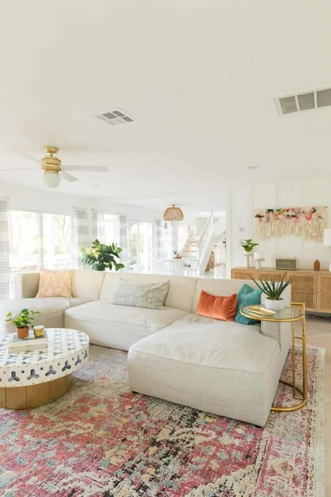 Tan Coach Living Room, Subtle Boho Living Room, Living Room Boho Colorful, Colorful Boho Design, Apartment Decorating Coastal Style, Bright Living Room Rug, Pink Rug In Living Room, Area Rug Aesthetic, Girly Apartments Living Room