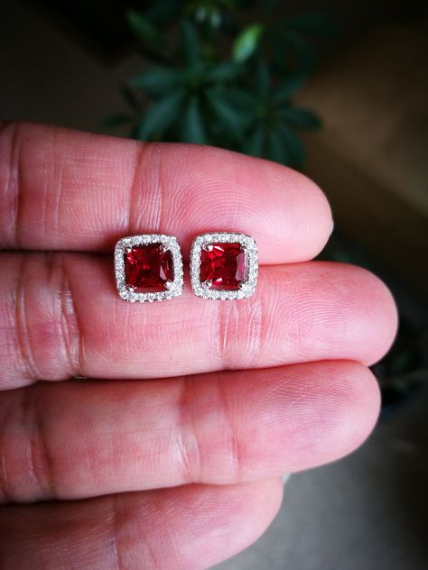 These Halo Ruby Diamond Stud Earrings are one of a kind. They look fabulous and beautiful when worn. These pair of Princess cut Red Ruby with Halo of Round shape simulated diamonds is excellent cut, Bright White D Color, and VVS1 Purity. Ideal for wear at the office, an evening out for dinner or a celebration of birthdays or weddings. It is a sure winner and could be a perfect earring for several occasions and everyday wear. These Earrings feature push backs for secure locking. Comes with a perf Princess Cut Earrings, Red Ruby Earrings, Diamond Halo Earrings, Studs For Men, Sliver Earrings, Halo Diamond Earrings, Ruby Earrings Studs, Halo Earrings, Gold Jewelry Simple