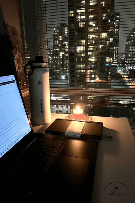 An open laptop on a desk beside a candle and planner with a nighttime cityscape in the background. Working Late At Night Aesthetic, Night Time Routine Aesthetic Photos, Night Office Aesthetic, Writing At Night Aesthetic, Night Time Study Aesthetic, Early Adulthood Aesthetic, College Night Aesthetic, Study At Night Aesthetic, Late Night Studying Aesthetic Motivation