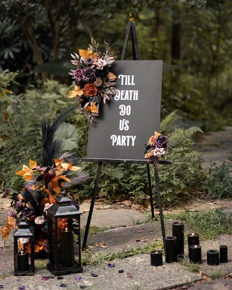 If you’re anything like us, you believe that Halloween vibes shouldn’t be confined to October 31st. You deserve to celebrate tricks, treats, and all things pumpkin spice whenever you feel like it. That includes your wedding day! We created our 2023 Halloween wedding collection for hopeless dark romantics like you. Shad Outdoor Halloween Wedding Decorations, Modern Goth Wedding Decor, Witchy Wedding Ceremony Decor, Small Black Wedding Ideas, Dark Wedding Signs, Black And Deep Purple Wedding, Dark Moody Wedding Reception, Black Purple Orange Halloween Wedding, Edgy Boho Wedding