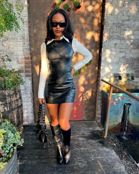 Black leather boots, black leather dress, white button up Black Leather Dress Styling, Black Leather Skirt With Boots, Leather Dress And Sneakers, Brown Leather Outfits For Black Women, Leather Dress Outfit Black Women, Outfits With Leather Boots, Short Dress And Boots Outfit, Short Satin Dress Outfit, Leather Dress Fall