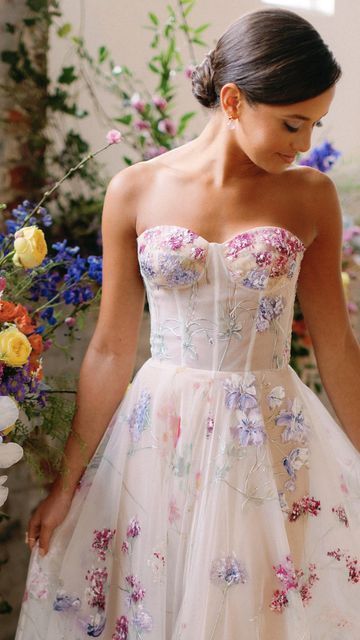 💐Floral Wedding Gowns💐  Which of these Hand-painted gowns is your favorite? A colorful wedding dress is the perfect focal point for a modern bride looking for some color for her wedding. Beautiful feminine shades of pink and purple! Brides Party Dress, Wedding Dress With Flowers On Skirt, Wedding Dress With Colorful Accents, Wedding Dress With Colourful Flowers, Reception Dress Floral, Floral Colorful Wedding Dress, Unique Wedding Dresses Floral, Bright Floral Wedding Dress, Colorful Bridal Dress