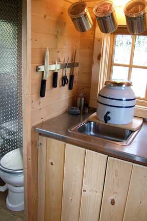 A few good space saving kitchen ideas: Magnetic knife holders and hanging lidded containers. Off Grid Kitchen, Dry Cabin, Tumbleweed Tiny Homes, Off Grid Tiny House, Tiny House Company, Building A Tiny House, Off Grid Cabin, Tiny Cabins, House Names