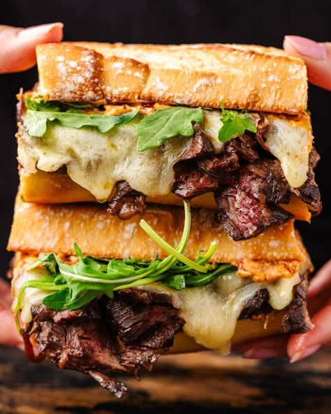 The best steak sandwich combines a perfectly toasted baguette that's piled with sliced skirt steak, caramelized onions, melted provolone, baby greens, and the easiest chipotle mayo. This sandwich is truly impossible to resist! #steaksandwich #steak #sandwiches Steak Panini Sandwiches, Steak Sandwich Sides, Sirloin Steak Sandwich Recipes, Steak Sandwich Marinade, Flank Steak Sandwich Recipes, Skirt Steak Sandwich Recipes, Shaved Steak Sandwich Recipes, Steak Sandwich Recipes Easy, Steak And Onion Sandwich