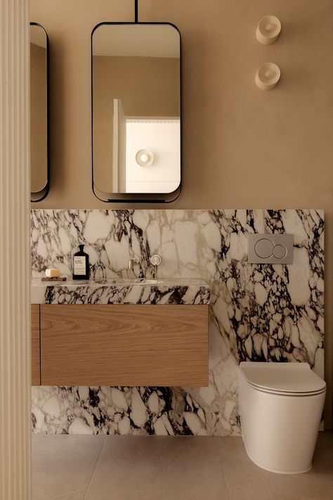 Marble ensuite vanity. Powder Room Architectural Digest, Bathroom With Mirror Wall, Marble Bathroom Inspiration, Mirror Over Vanity And Toilet, Transitional Primary Bathroom Design, Contemporary Classic Bathroom, Marble Baseboard In Bathroom, Vanity Next To Toilet, Quiet Luxury Bathroom