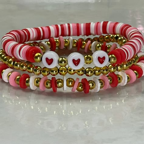 Set of 3 Valentine stretch braceletsFits most wristsPerfect for Valentine's DayIncludes a red and white heart braceleta red and white gold bead braceletand a plain gold bead bracelet. Heart Clay Bead Bracelet, Valentines Bracelets Ideas, Valentine’s Bracelets, Valentine Clay Bracelets, Valentines Beaded Bracelet Ideas, Valentine Bracelets Beads, Valentine’s Day Beaded Bracelet, Valentine Clay Bead Bracelet Ideas, Valentine’s Day Bracelet