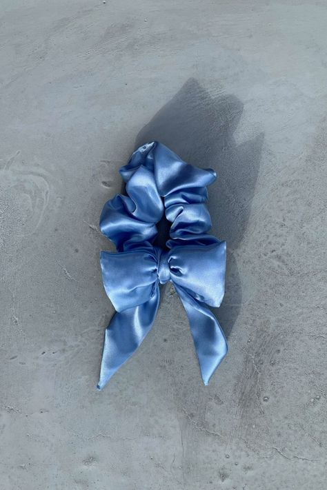 A ice blue satin hair bow scrunchie lying on a cement background. Bow Scrunchie, Hair Bow, Hair Ties, Scrunchies, Hair Bows, Satin, Ships, Hair