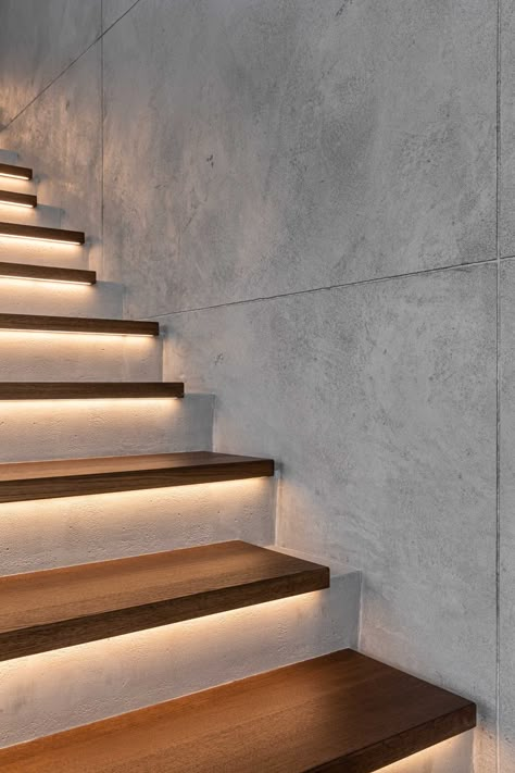 A modern home with concrete and wood stairs, that also include hidden lighting underneath the treads Hall Stairs And Landing Decor, Stairs Lighting Ideas, Painted Stair Railings, Landing Decor, Stair Railing Makeover, Indoor Stairs, Stairs Lighting, Modern Stair Railing, Concrete Staircase