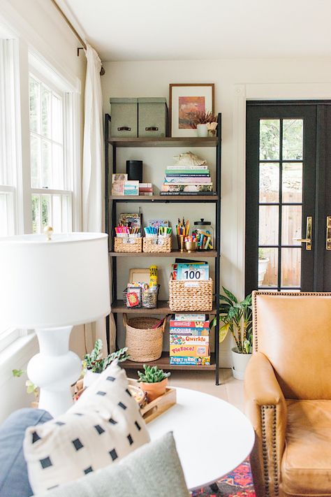 Bookcase With Toy Storage, Bookshelf In Playroom, Chair Next To Bookshelf, Bookshelf Family Room, Bookshelves Next To Window, Living Room Corner Storage, Kids Bookshelf Decor, Family Room Organization Ideas, Small Living Room Eclectic