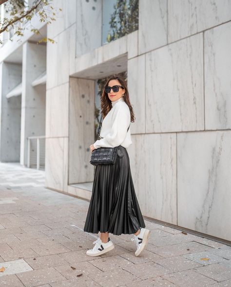 Fall outfit idea, black faux leather pleated skirt, white sweater and Veja sneakers! Click the link to shop! Faux Leather Pleated Skirt Outfit, Leather Pleated Skirt Outfit, White Sneakers With Dress, White Pleated Skirt Outfit, Pleated Skirt And Sneakers, Pleated Skirt Outfit, Monochrome Style, White Pleated Skirt, Black White Outfit