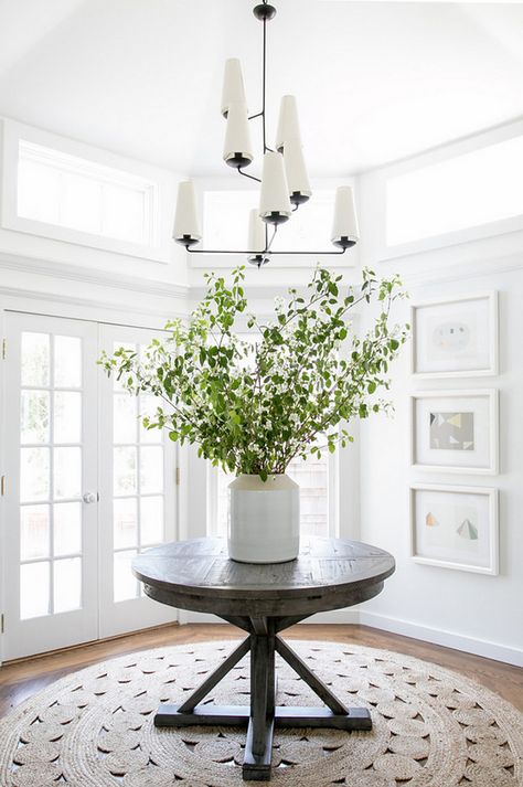 Modern Farmhouse Foyer features round driftwood table and modern chandelier from Circa Lighting | Chango & Co. Modern Farmhouse Foyer, Round Foyer, Round Foyer Table, Round Entry Table, Farmhouse Foyer, Round Jute Rug, Foyer Furniture, Driftwood Table, Farmhouse Entryway