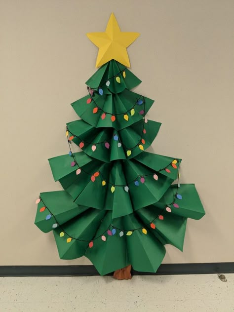 3-D Christmas tree bulletin board. Paper Tree Classroom Christmas, Christmas Tree Ideas For Classroom, Classroom Paper Christmas Tree, Diy Christmas Tree Classroom, Paper Christmas Tree Door Decoration, Christmas Tree Out Of Construction Paper, 3d Christmas Bulletin Boards, Christmas Wall Decorations For School, 3d Paper Christmas Tree On Wall