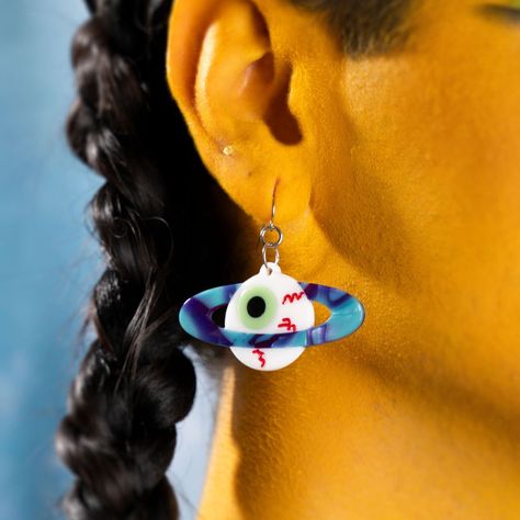 It's a weird planet, isn't it? These creepy little eyeball earrings have a sparkly blue and purple planet ring, and make an awesome addition to any outfit. Very punk, very weird, very cool. 2" in length. Eyeball Earrings, Planet Ring, Planet Earrings, Planets, Blue And Purple, Purple