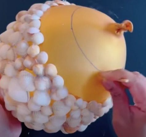 Woman uses hot glue and balloons to make the most adorable seashell flower pots Seashell Pots Planters, Sea Shell Candle Holders Diy, Seashell Planter Ideas, Seashell Flowers How To Make, Diy Shell Projects, Shell Gifts Diy, Sea Shell Projects Diy, She’ll Christmas Ornaments, Resin With Shells