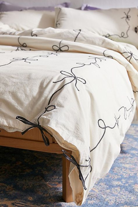 Our fave femme icon gets a chic refresh with this lightweight cotton embroidered duvet cover. Its crisp construction features textural bows stitched allover the top panel with a solid cotton panel at the reverse for a silky-soft finish. Pair it with our Lacey Bows Sham Set for a coordinated bedding set. Available exclusively at Urban Outfitters. Features Chic bow duvet cover from UO Home in crisp cotton Finished with textural bows allover the top panel Backed with a solid cotton panel Hidden but Bow Bedding Urban Outfitters, Cute Room Bedding, Black And Pastel Bedroom, Blue Bedroom With Red Accents, Winter Duvet Cover, White Bed With Colorful Accents, Bed Sheets Black And White, Textured Bedding Ideas, Urban Outfitters Duvet Cover