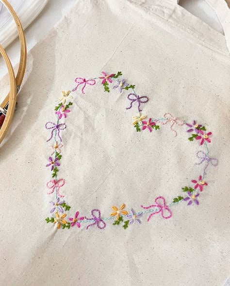 ♡︎𝐇𝐞𝐚𝐫𝐭 𝐓𝐨𝐭𝐞♡︎ Embroidered tote bag for a girl who loves her coquette bows and flowers🎀🌸🌱Thank you so much @aa_dummy00 for trusting me with this order!💗 #embroidery #totebag #coquette #flowers #embroideryart #embroiderydesign #flowerstagram Embroidered Purse Diy, Tote Bag With Embroidery, Embroidery Present Ideas, Cute Tote Bag Ideas, Aesthetic Embroidery Designs, Embroidered Tote Bag Ideas, Tote Bag Flower Design, Tote Bag Embroidery Design, Flower Stitch Embroidery