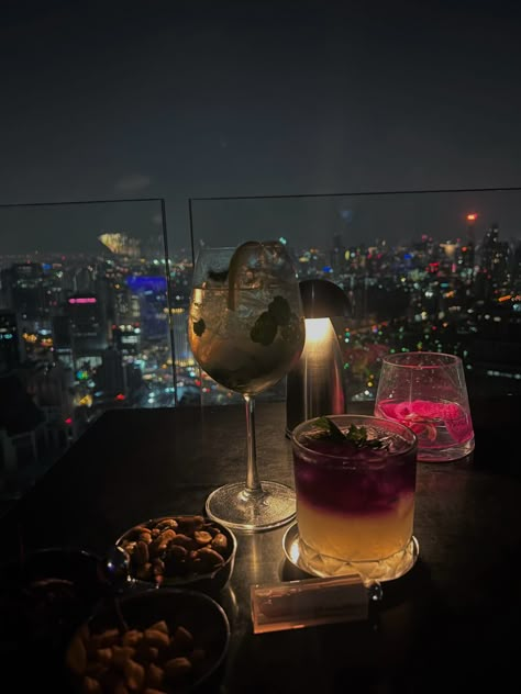 Drinks at a Table, Luxury at a Rooftop Bar, Skyscraper, Bangkok, NYC Vibes #DrinksAtATable #LuxuryRooftopBar #SkyscraperViews #BangkokNightlife #NYCVibes #TableDrinks #RooftopDrinkSpecials #CityscapeViews #RooftopMixology #ManhattanNights #BangkokSkyline #NightlifeEscapes #CocktailHour #UrbanGlamour #MetropolitanElegance #SkyHighSips #luxurylife #drinks #cocktails #aestheticcocktails Thailand Rooftop Bar, Rooftop Vibes Aesthetic, Nyc Rooftop Bar Aesthetic, Rooftop Bar Aesthetic Night, Drink With Friends Aesthetic, Rooftop Date Aesthetic, Rooftop Dinner Aesthetic, Drinks Night Out, Bangkok Rooftop Bar