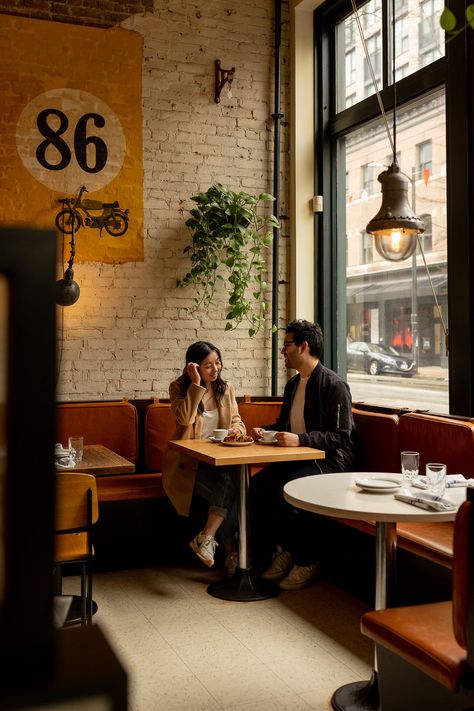 couple sitting in gastown coffee shop during engagement session Couple Poses Coffee Shop, Couple At Coffee Shop Aesthetic, Pre Wedding Shoot Ideas In Cafe, Coffee Shop Prenup Shoot, Couples Cafe Photo, Cafe Prenup Shoot, Engagement Pictures Coffee Shop, Coffee Shop Proposal, Coffee Shop Engagement Shoot Photo Ideas